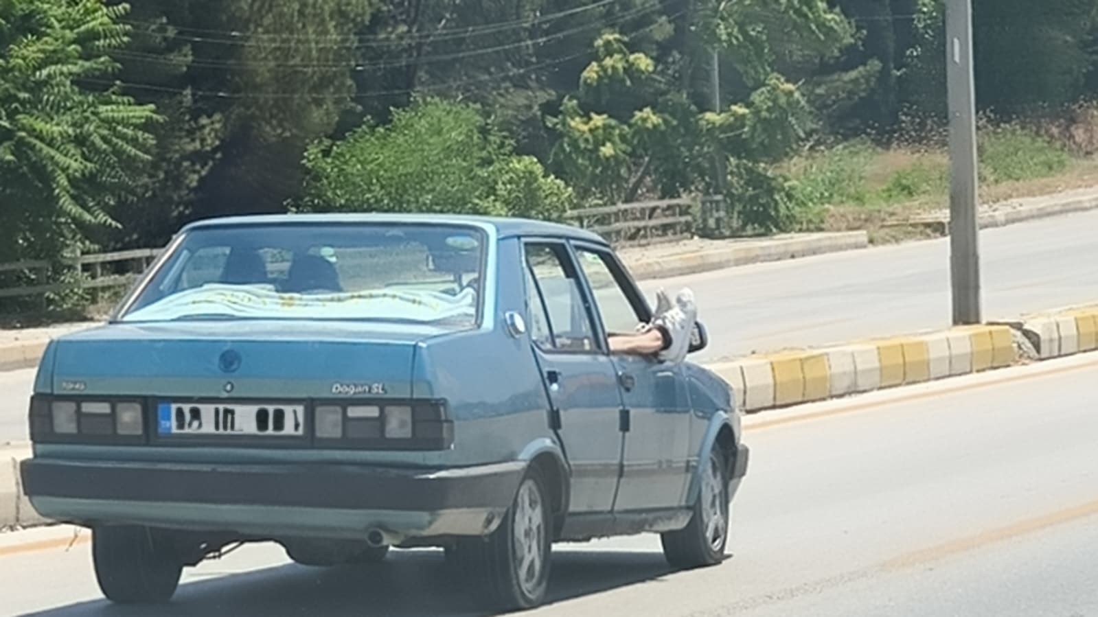 Ayaklarını camdan dışarı çıkartan yolcu trafiği riske attı
