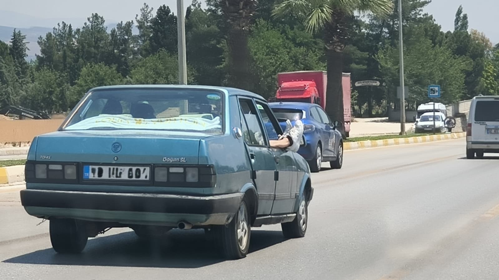 Ayaklarını camdan dışarı çıkartan yolcu trafiği riske attı
