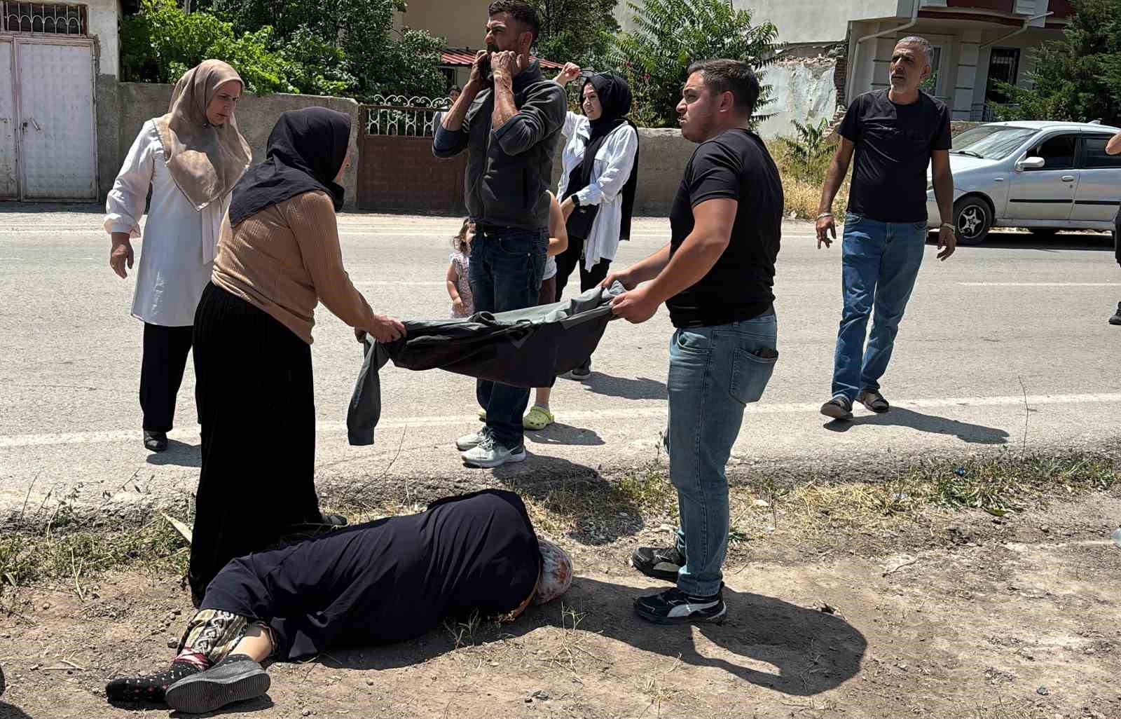 Yerde yatan yaralı kadına mont ile gölgelik yaptılar