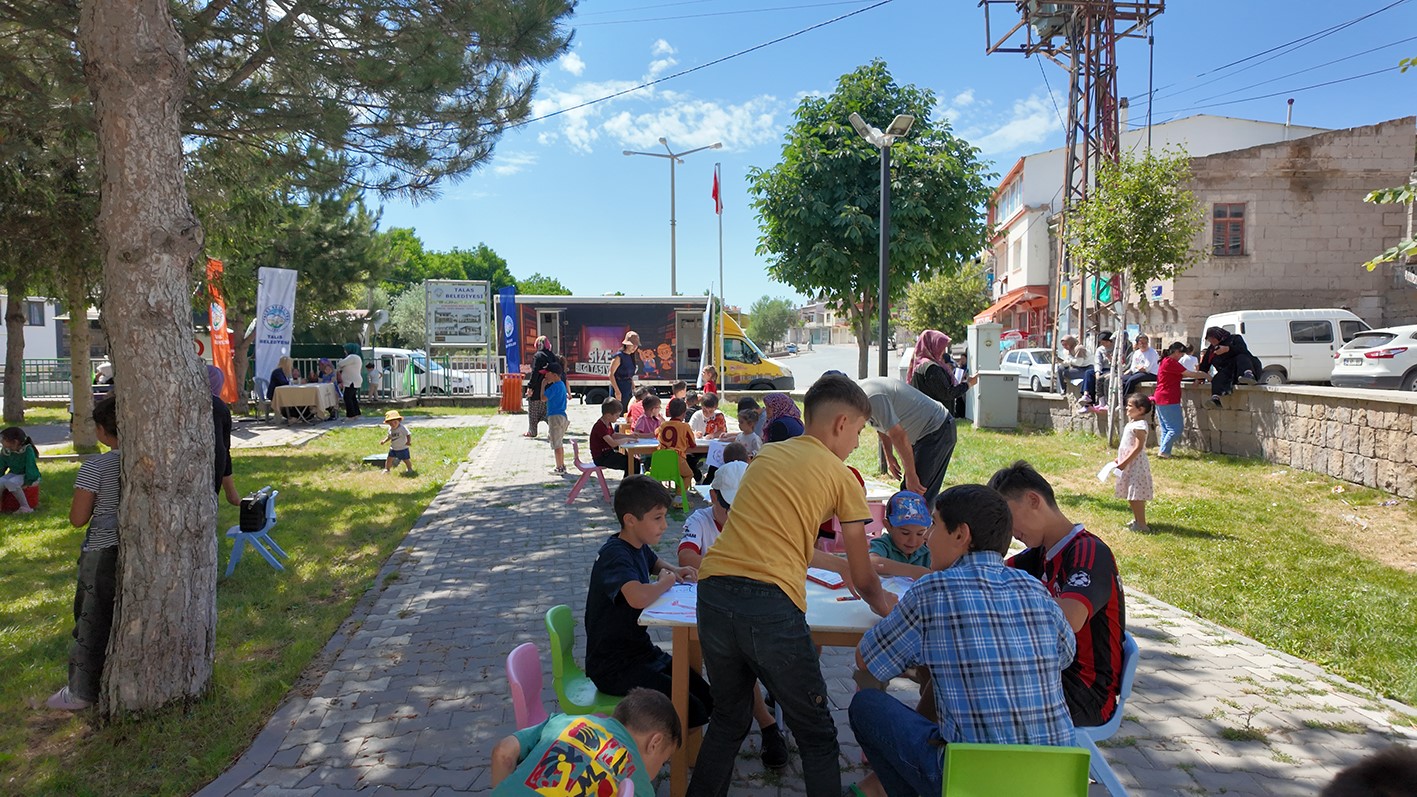 Kütüphane geziyor, çocuklar hem okuyor hem eğleniyor