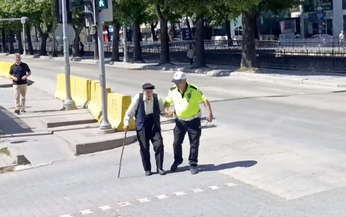 Trafik polisinin yürümekte zorlanan yaşlı adama yardımı yürekleri ısıttı